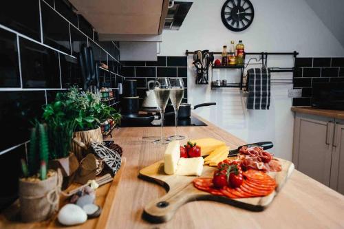 - un comptoir de cuisine avec une planche de coupe et de la nourriture dans l'établissement Boho Loft in Somerset - Private Parking, à Radstock