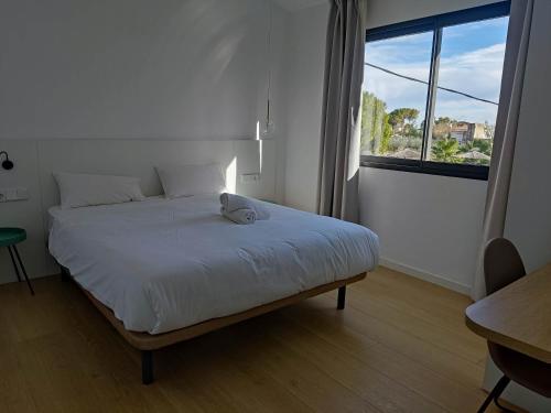 1 dormitorio con cama blanca y ventana grande en CASA MARISA, en Alcanar