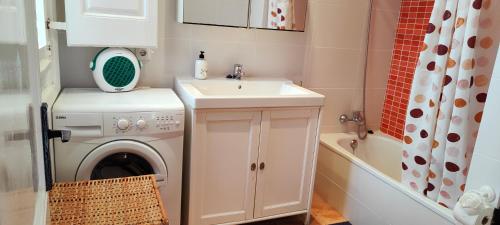 a bathroom with a washing machine and a sink at Casa con jardín a 30 metros de la playa. VC. in Palamós