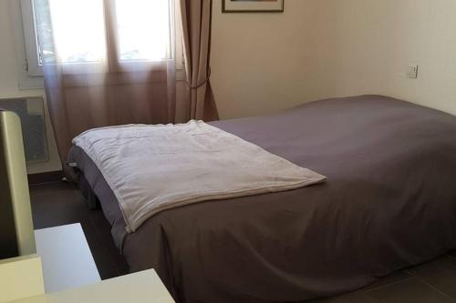 a bed sitting in a room with a window at COSY FLAT in Bussy-Saint-Georges
