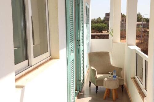 a chair and a table on a balcony at Résidence Marie France MENDY in Toubab Dialaw