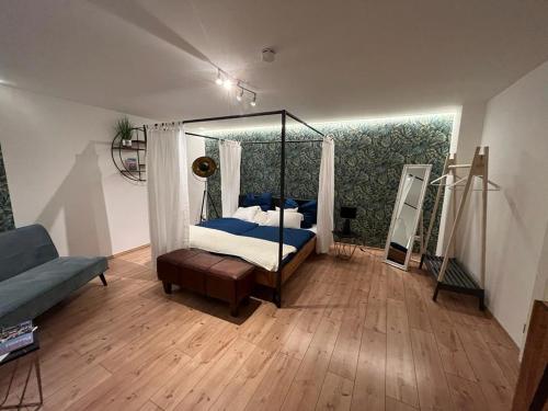 ein Schlafzimmer mit einem Himmelbett und einem Sofa in der Unterkunft Alte Schmiede in Passau