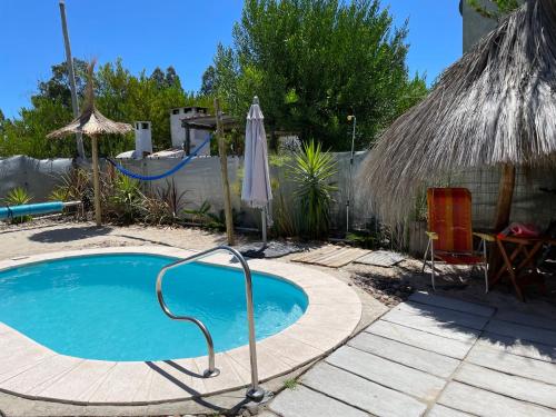 a small swimming pool with an umbrella and a table at Los Fernández in Jaureguiberry