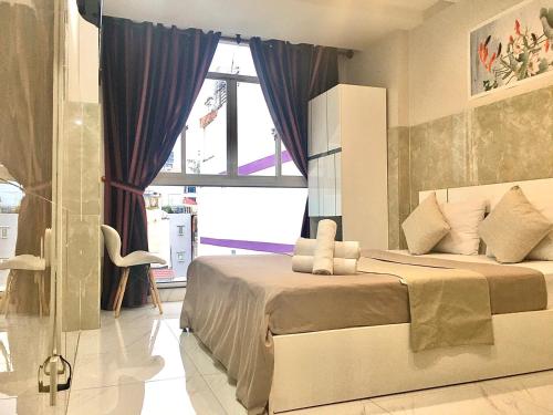 een slaapkamer met een groot bed en een raam bij SaiGon CoZy Hotel "241 Pham Ngu Lao Street'' in Ho Chi Minh-stad
