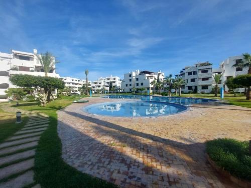 uma piscina num resort com edifícios ao fundo em la Cassia Cabo Appartement em Cabo Negro