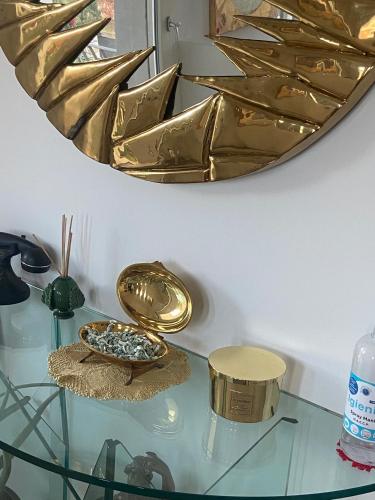 a glass table with a gold mirror on a wall at My Comfort in Treviso