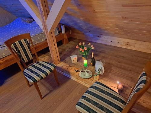 a wooden room with a table with a candle and flowers at Saules Rats Apartamenti in Madona
