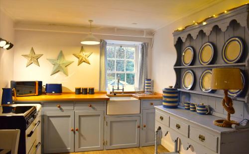 una cocina con armarios blancos y estrellas en la pared en Corrie Apartment en Appin