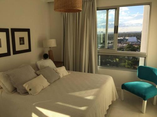 1 dormitorio con cama y ventana grande en DEPARTAMENTO OCEAN DRIVE CON ATARDECER, en Punta del Este