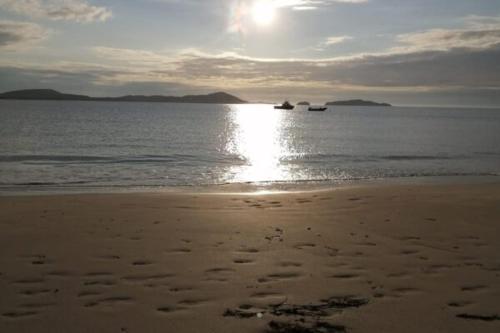 a beach with two boats in the water at Donegal Luxury Pods in Gweedore