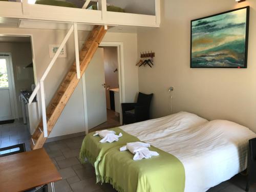 1 dormitorio con 1 cama con 2 toallas en Oldfruen - Rooms & Apartments, en Bøtø By