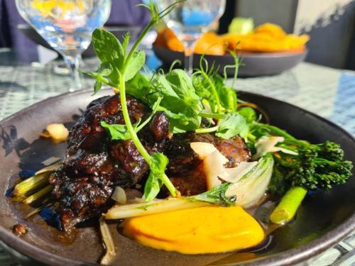 a plate of food with meat and vegetables on a table at Benguela Cove - Oceans Away in Hermanus