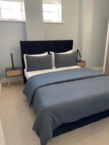 a bedroom with a large bed with blue sheets and pillows at Luxurious Private One Bedroom Apartment in Braintree with Free Parking Near City Centre in Braintree