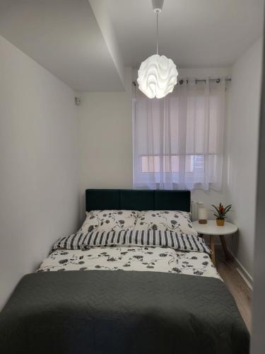 a bedroom with a bed and a pendant light at Apartament z widokiem-Bliżej Zdroju in Polanica-Zdrój