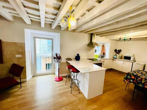 a kitchen with a table and chairs in a room at Apartamentos La Selva in Cádiz