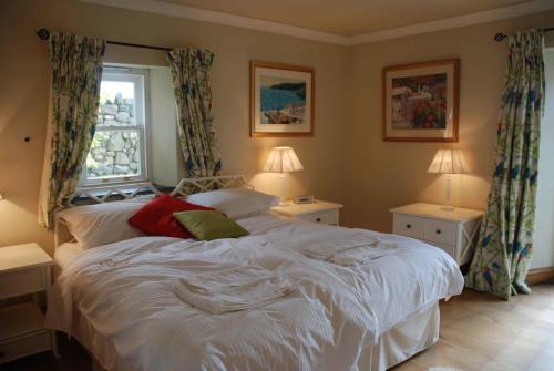 a bedroom with a white bed and a window at The Elephants Nest Inn in Marytavy