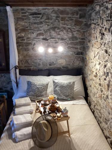 a bed with a table with a hat on it at Casa Charma in Émbonas