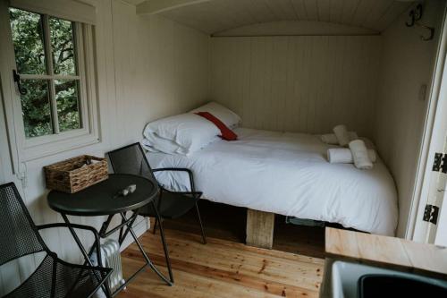 a small room with a bed and a table and chairs at Snowdonia Shepherds Hut + Hot Tub in Barmouth