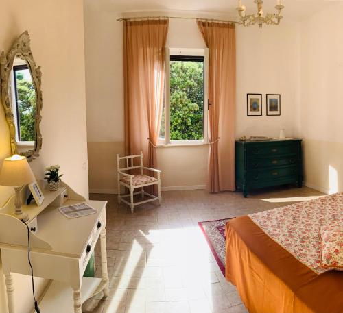 a bedroom with a bed and a desk and a mirror at Podere Gradisca in Alberese