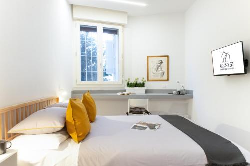 a bedroom with a large white bed with yellow pillows at Suite Apartments - Corso51 in Rimini