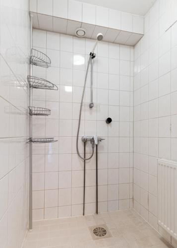 a shower in a bathroom with white tiles at Cozy Studio - 7 min to Tampere Airport - Free Parking in Pirkkala