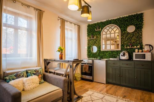a kitchen with green walls and a table and a couch at Hanul Anei in Braşov