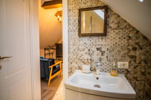 a bathroom with a sink and a mirror at Hanul Anei Studios and Apartments Brasov Transylvania in Braşov