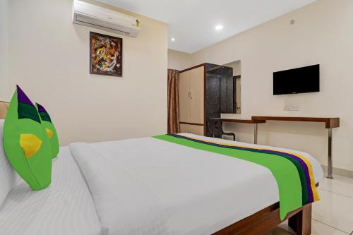 Un dormitorio con una cama blanca y un escritorio. en Treebo Virat Residency, US Consulate, en Hyderabad