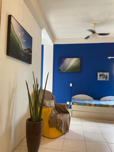 Habitación con una pared azul y una cama en Apto confortável próximo a praia, en Balneário Camboriú