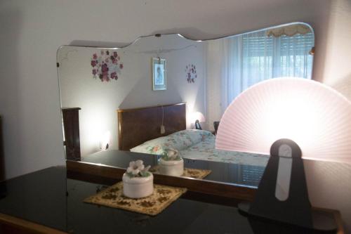 1 dormitorio con espejo grande y cama en APPARTAMENTI PANORAMICI VISTA MARE en Castiglione della Pescaia