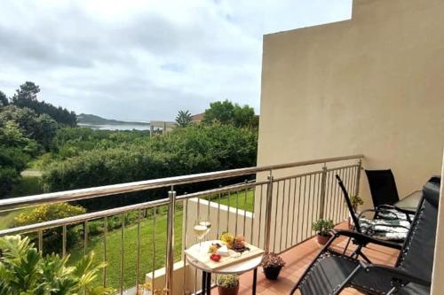 a balcony with a table and chairs and a view of the ocean at I 6 Goose Valley! Golf and more in Plettenberg Bay