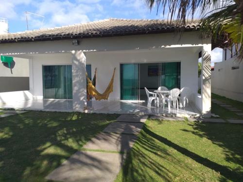 a house with a table and chairs in the yard at Casa Beira Mar Serrambi in Porto De Galinhas