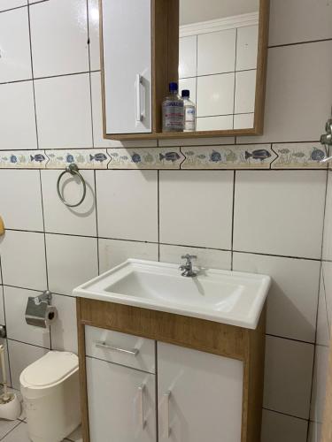 y baño con lavabo y aseo. en Apto confortável próximo a praia, en Balneário Camboriú