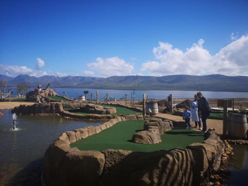 a group of people standing on a miniature golf course at Benguela Cove - Oceans Away in Hermanus