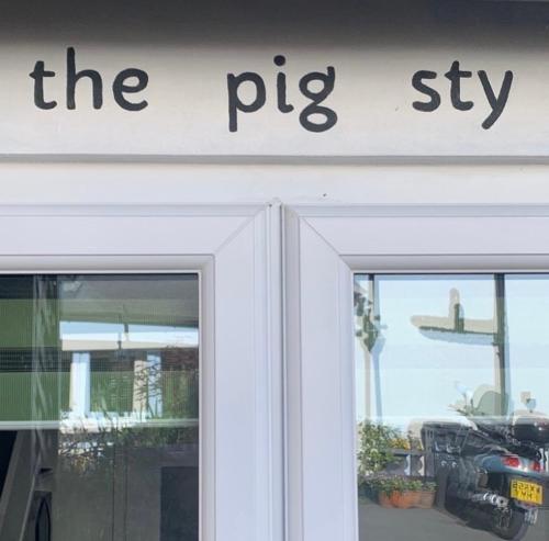 a sign on the top of a shop door at The Pigsty in Braunton in Braunton