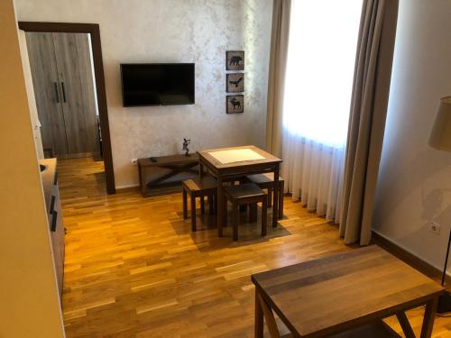 a living room with a table and chairs and a television at Kolakovic in Brzeće