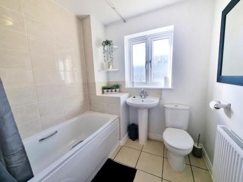 a bathroom with a tub and a toilet and a sink at Stylish 3 Bedrooms & 2 Bathrooms House, Free Parking! in Cambridge