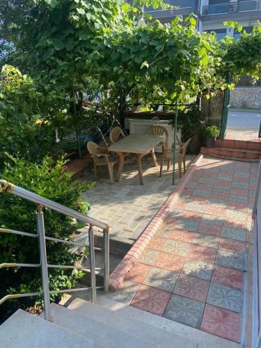 a patio with a table and chairs and trees at Sure Hause in Değirmendere