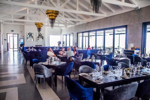 a restaurant with tables and chairs and people sitting at them at Benguela Cove - Oceans Away in Hermanus