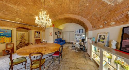 a dining room with a table and a chandelier at Sestosenso Suites in Campiglia Marittima