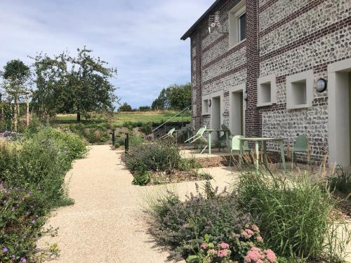 una casa in mattoni con patio e fiori di fronte di Les Sept Logias a Les Loges