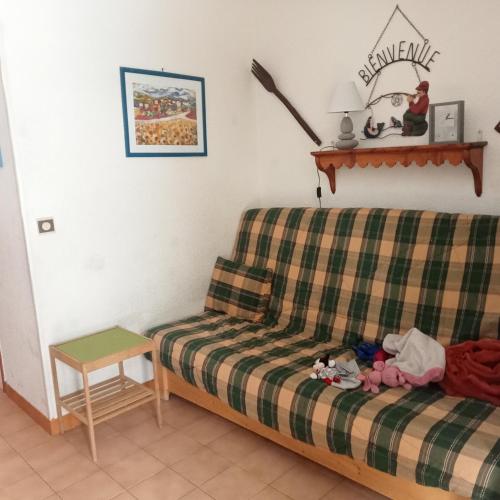 1 dormitorio con sofá a cuadros y mesa en Le stella Ancelle, en Ancelle