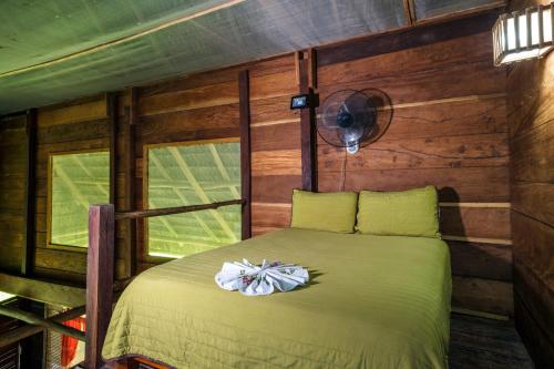a bedroom with a bed in a room with wooden walls at Las Guacamayas Lodge, Selva Lacandona, Chiapas México in Tlatizapán
