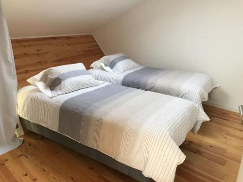 Duas camas num quarto com pisos de madeira em CASA DO ESTÁBULO - Vila Garcia - Trancoso 