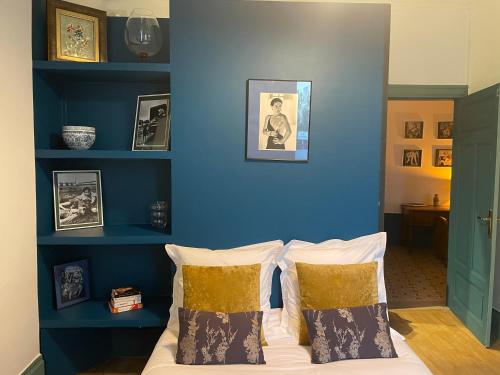 sypialnia z niebieskimi ścianami i łóżkiem z poduszkami w obiekcie Appartement Signature Art Déco w mieście Valence