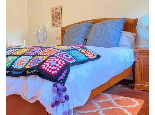 a bed with a colorful blanket on top of it at Pilgrim Stop Over - Tomar Village 