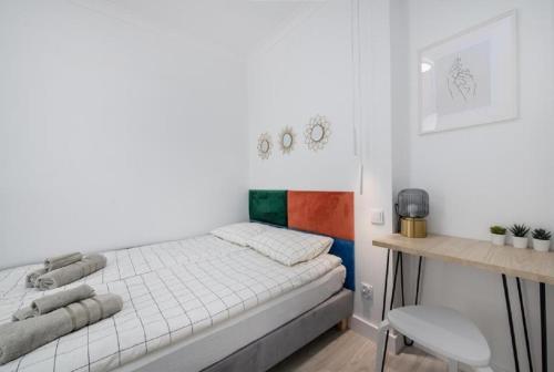 een witte slaapkamer met een bed en een bureau bij Apartament na Rybakach in Gdańsk