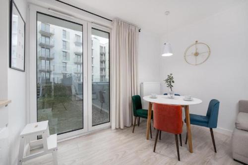 een woonkamer met een tafel en stoelen en een raam bij Apartament na Rybakach in Gdańsk