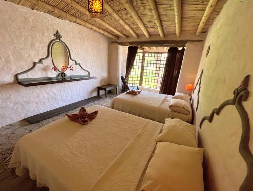 a room with three beds and a mirror on the wall at Darenas Hacienda in Aucallama