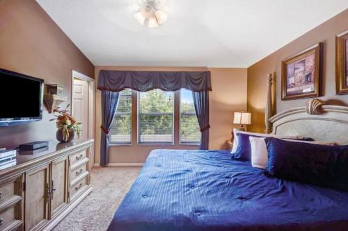a bedroom with a large blue bed and a window at Veteran Owned 3bdr/3 bath Townhouse w/WiFi 3mi to Disney - Winter/Spring Specials in Kissimmee